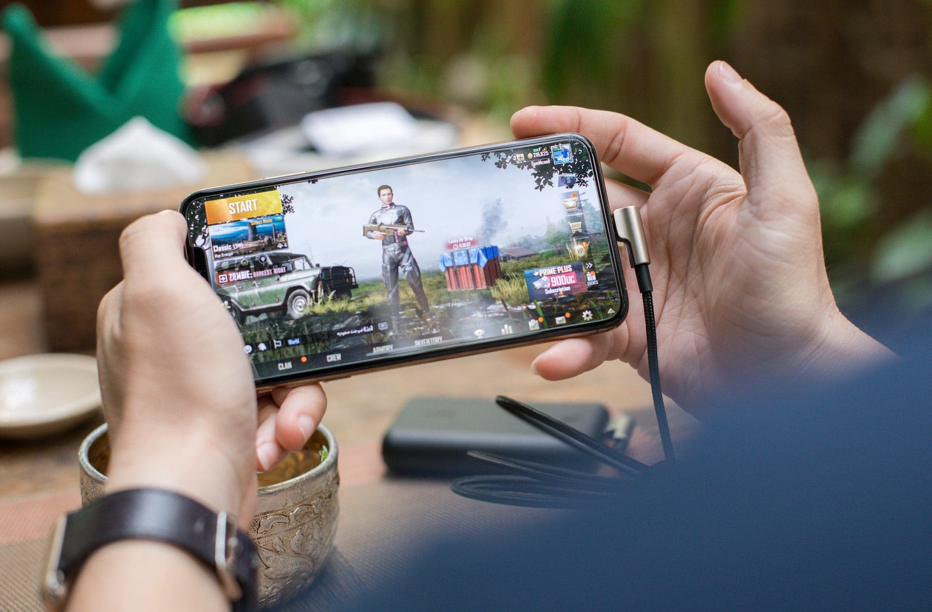 Man playing games on mobile phone to show the performance of native apps