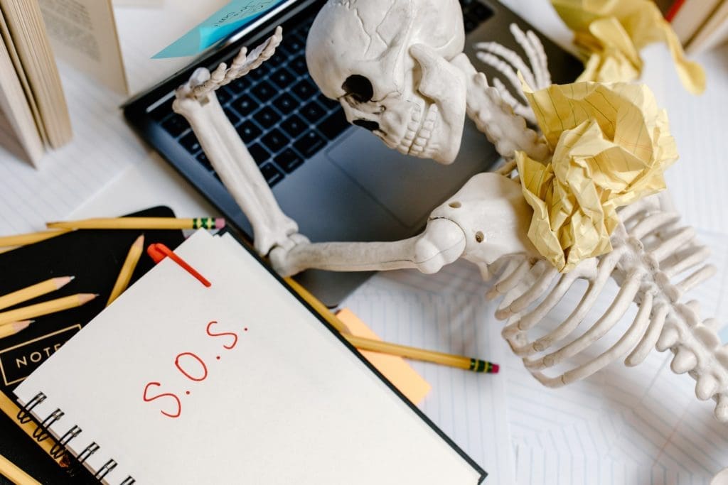 prop skeleton lying on laptop to symbolize developer suffering from not developing a product roadmap