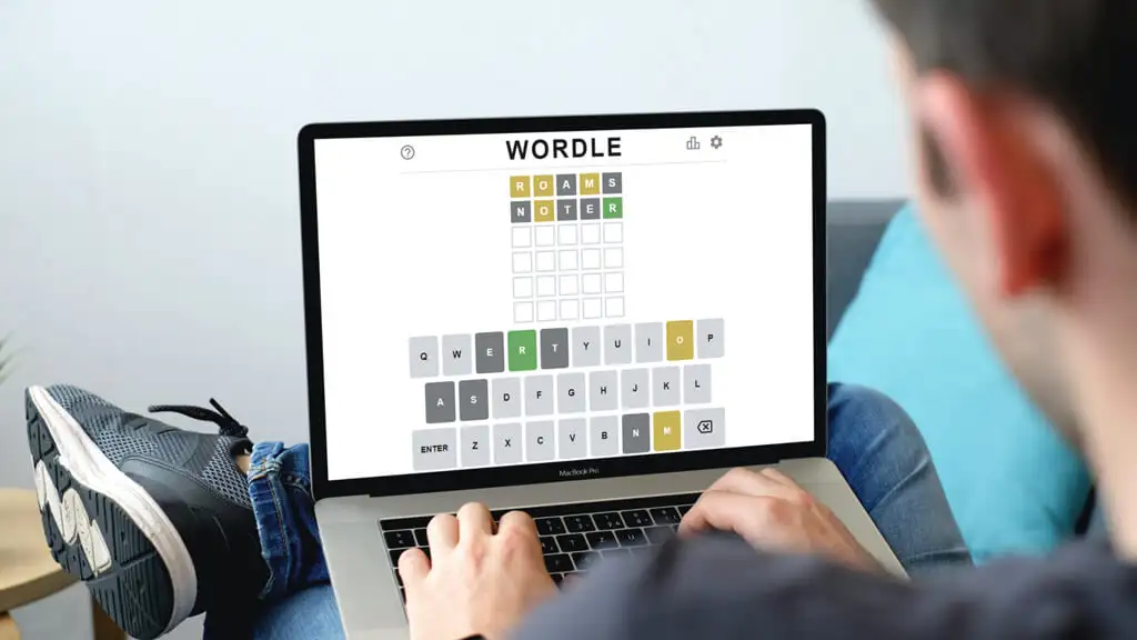 man playing wordle on web app on laptop